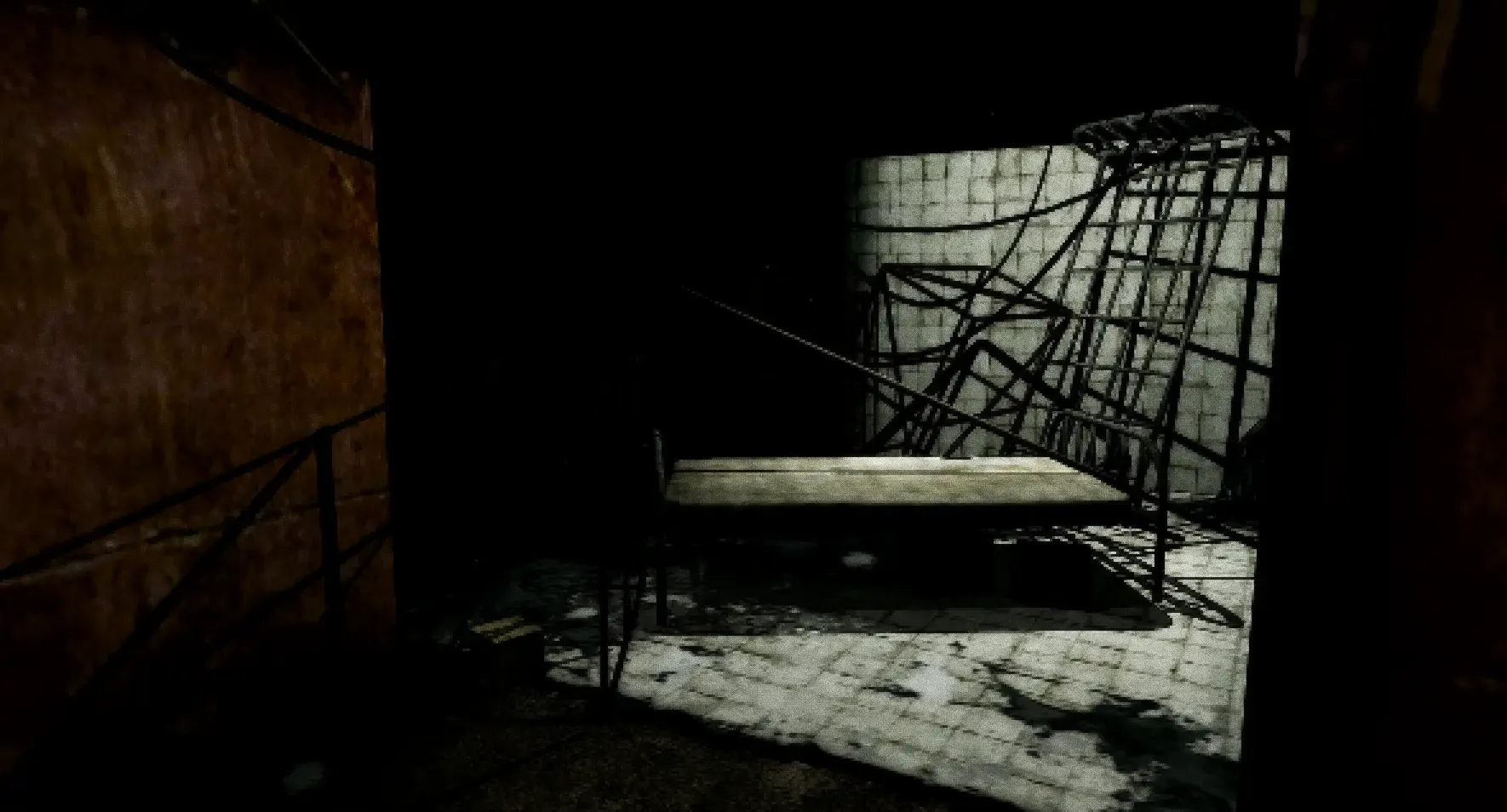 A dirty room with a horrible bed in the dark.
