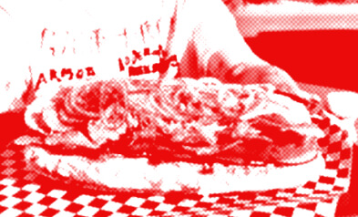 Someone holding out a hoagie on a platter.
